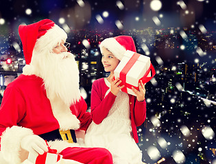 Image showing smiling little girl with santa claus and gifts