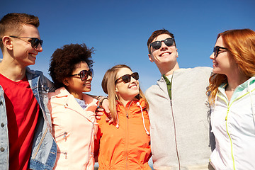 Image showing happy teenage friends in shades talking on street