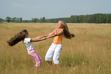 Image showing Girls plays on a meadow