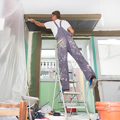 Image showing Plasterer renovating indoor walls and ceilings.