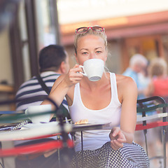 Image showing Woman drinking coffee outdoor on street.