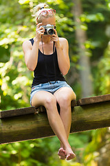 Image showing Woman in nature with retro camera.