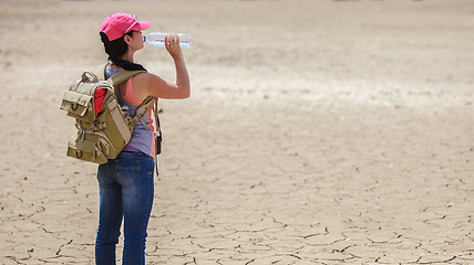 Image showing Traveller drinking water from bottle in the desert