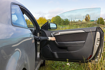 Image showing Human hand opens the car door In the countryside