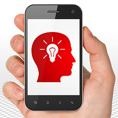 Image showing Advertising concept: Hand Holding Smartphone with Head With Light Bulb on display