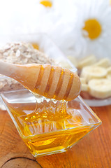 Image showing Honey in the glass bowl on the wooden table