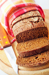 Image showing Fresh bread and knife on the wooden board