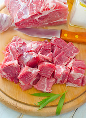 Image showing raw meat and knife on the wooden board