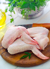 Image showing Raw chicken and knife on the wooden board