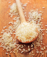 Image showing raw rice in the wooden spoon