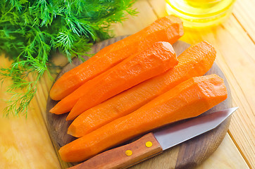 Image showing raw carrots and knife on the wooden board