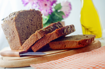 Image showing Fresh bread and knife on the wooden board