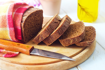 Image showing Fresh bread and knife on the wooden board