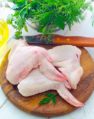 Image showing Raw chicken and knife on the wooden board