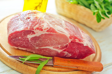 Image showing raw meat and knife on the wooden board