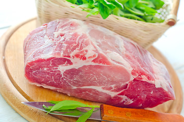 Image showing raw meat and knife on the wooden board