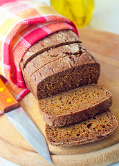 Image showing Fresh bread and knife on the wooden board