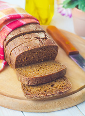 Image showing Fresh bread and knife on the wooden board