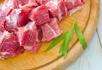 Image showing raw meat and knife on the wooden board