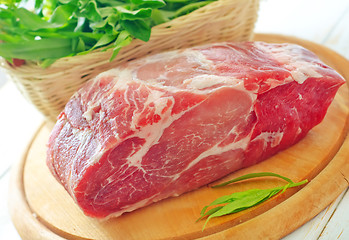 Image showing raw meat and knife on the wooden board