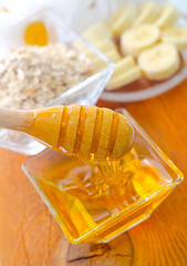 Image showing Honey in the glass bowl on the wooden table