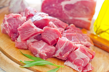 Image showing raw meat and knife on the wooden board