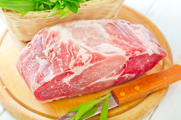 Image showing raw meat and knife on the wooden board