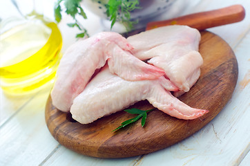 Image showing Raw chicken and knife on the wooden board