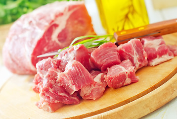 Image showing raw meat and knife on the wooden board