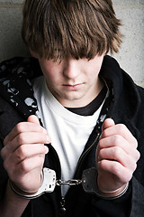 Image showing teen crime - kid in handcuffs