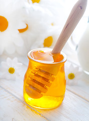 Image showing fresh honey in the glass bank and milk in jug