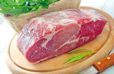 Image showing raw meat and knife on the wooden board