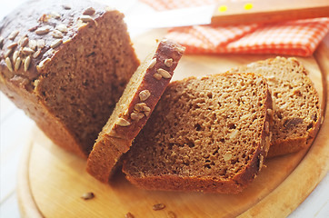 Image showing Fresh bread and knife on the wooden board