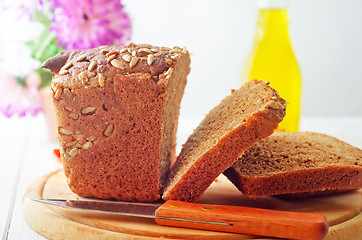 Image showing Fresh bread and knife on the wooden board