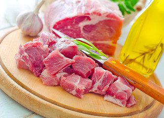 Image showing raw meat and knife on the wooden board