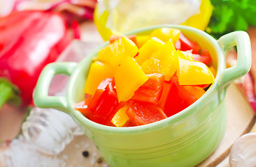 Image showing Rd and yellow peppers on wooden background