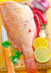 Image showing raw fish with aroma spice on wooden background