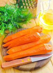 Image showing raw carrots and knife on the wooden board