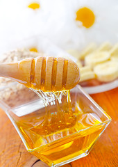 Image showing Honey in the glass bowl on the wooden table