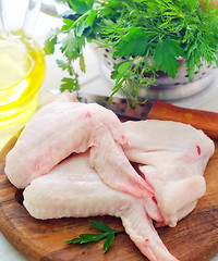 Image showing Raw chicken and knife on the wooden board