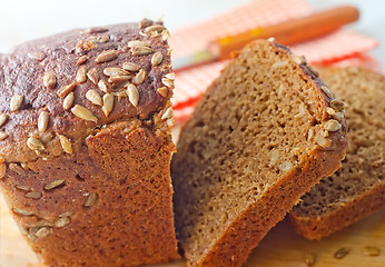 Image showing Fresh bread and knife on the wooden board