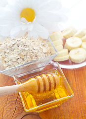 Image showing Honey in the glass bowl on the wooden table