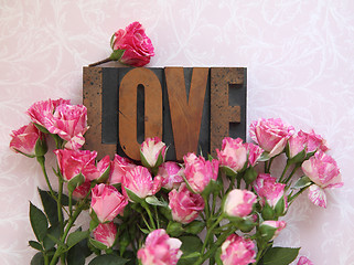 Image showing love word in wood type with roses