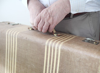 Image showing Man holds old suitcase.