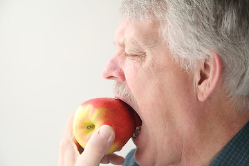 Image showing Senior eats apple.	