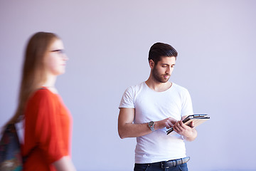 Image showing student working on tablet, people group passing by