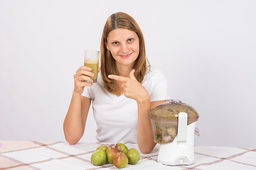 Image showing A girl holding a glass of fresh juice and points to it