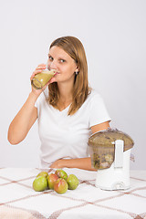 Image showing Girl drinks freshly pear juice