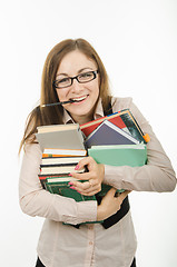 Image showing The teacher holds a pile of textbooks and notebooks