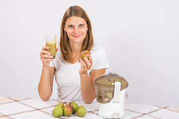 Image showing Girl with a pear and a glass of fresh juice in hand